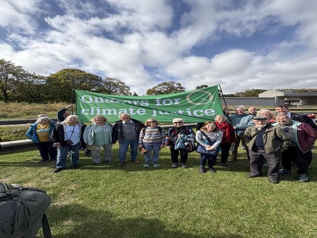 Several Quakers stand under a Quakers for Climate Justice banner outside the Scottish Parliament