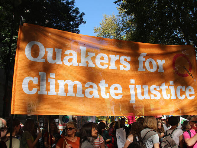 Pictures of Quakers holding an orange 'Quakers for climate justice' banner as part of the 2019 climate strike